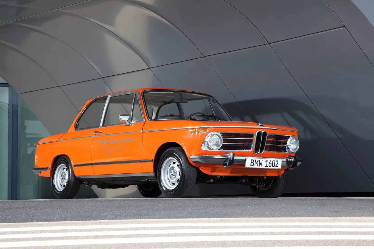 Classic Orange Bmw Parked in Front of Modern Building