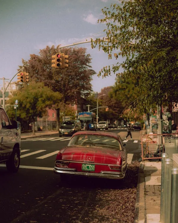Classic red Mercedes parked on sunny city street Wallpaper