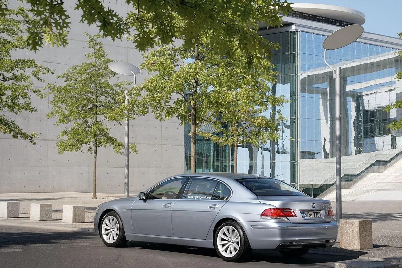 Classic Silver Bmw Sedan Driving Past Glass Building
