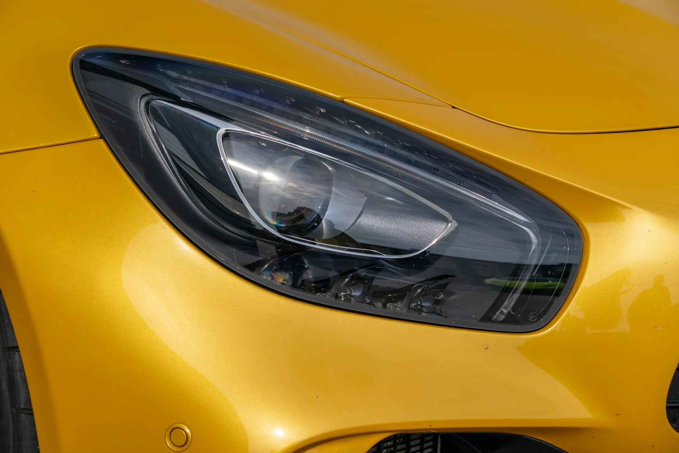 Close Up of Headlight on Yellow Mercedes Benz Sports Car