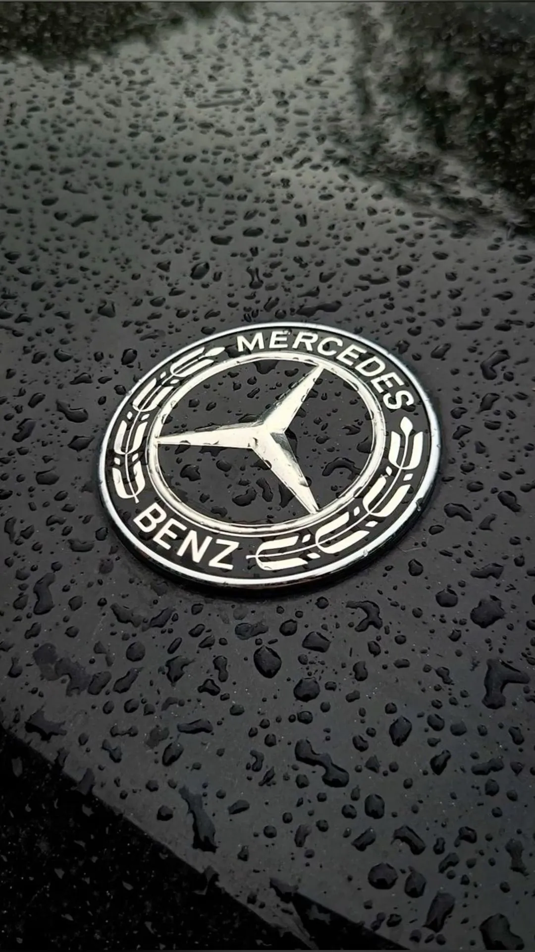 Close Up of Mercedes Benz Logo Emblem with Water Droplets