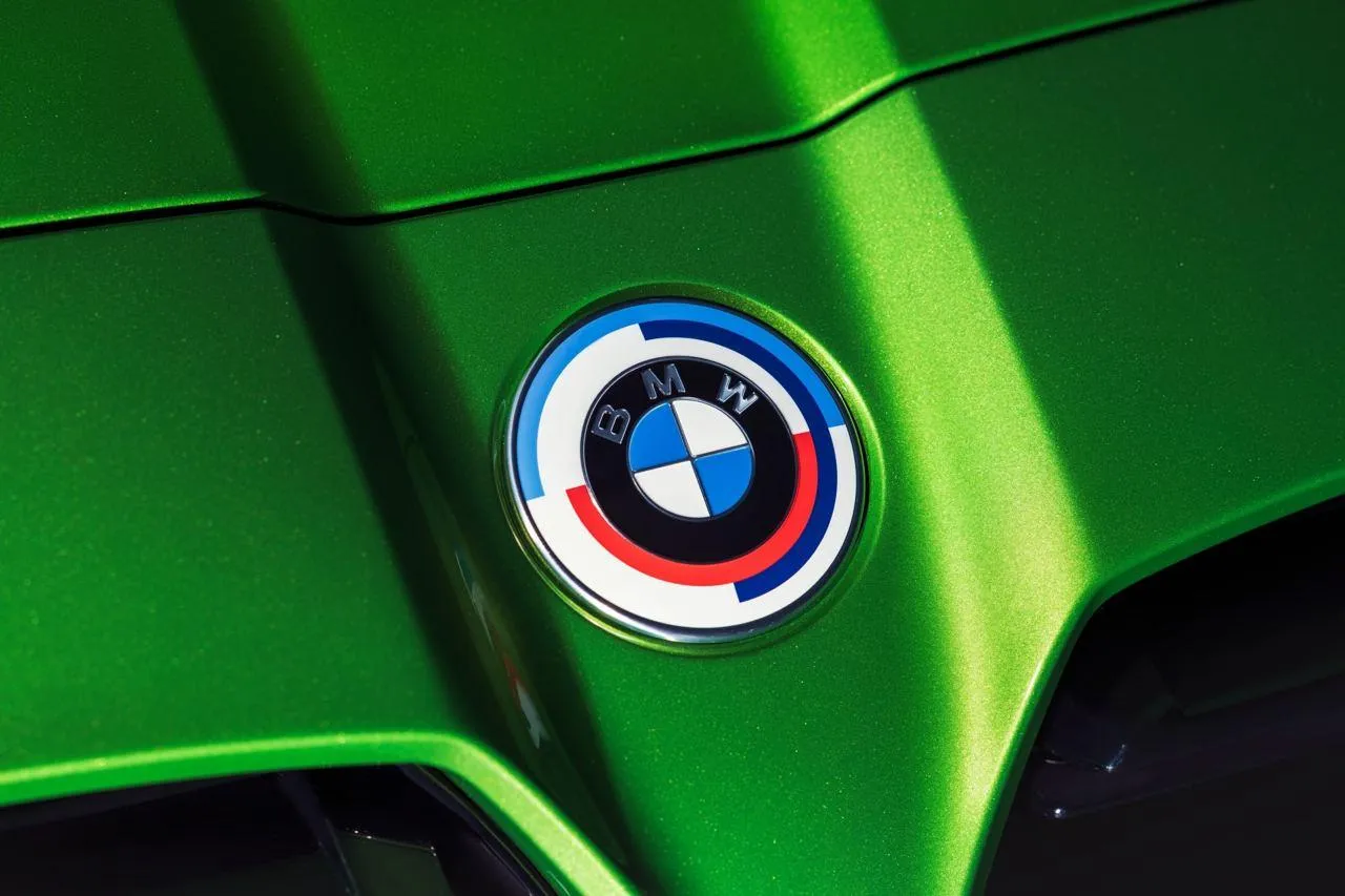 Close View of Bmw Logo on Shiny Green Sports Hood Wallpaper