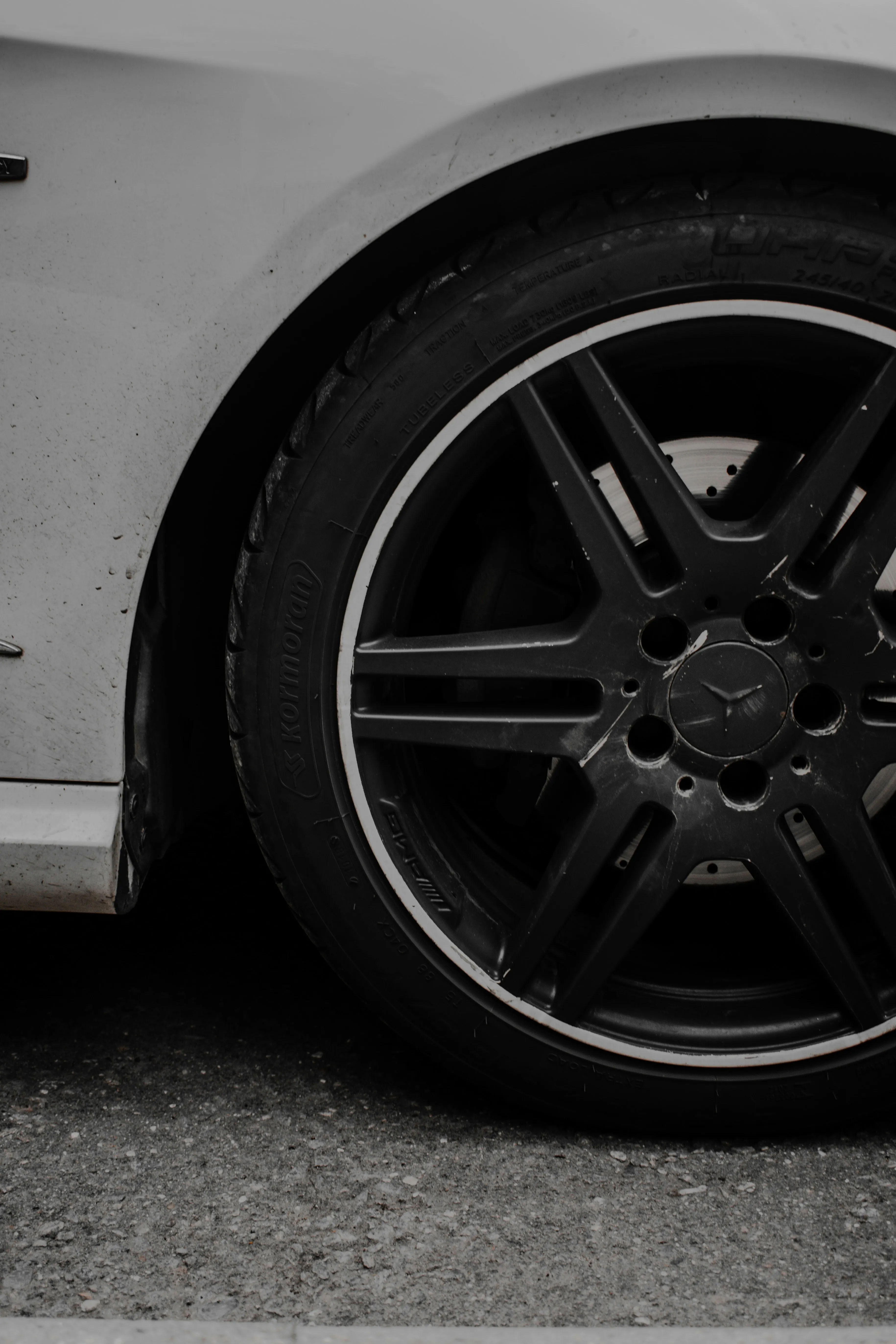 Closeup of Black Alloy Wheel on White Mercedes Benz