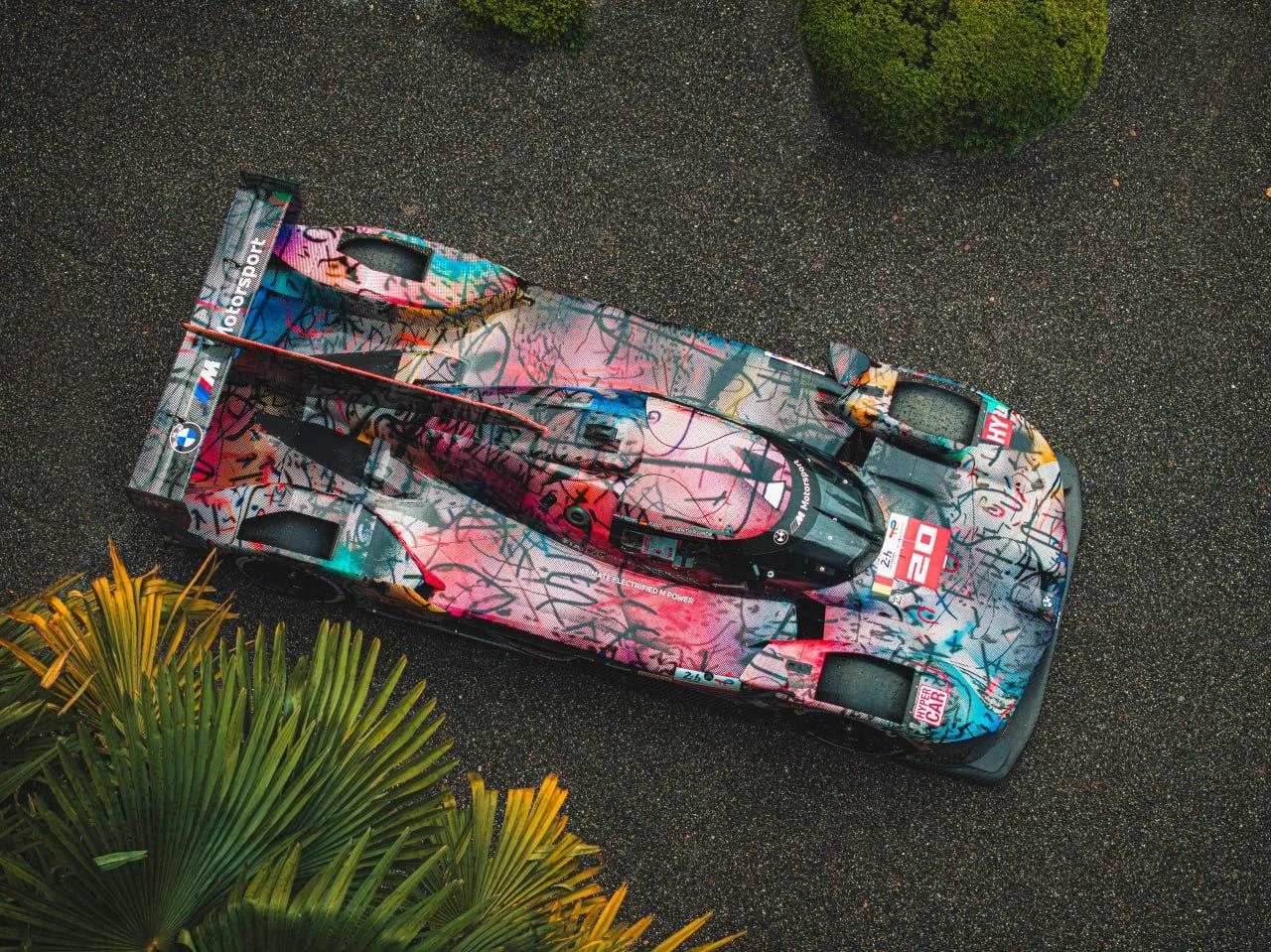 Colorful Bmw Art Car Displayed in Outdoor Green Setting