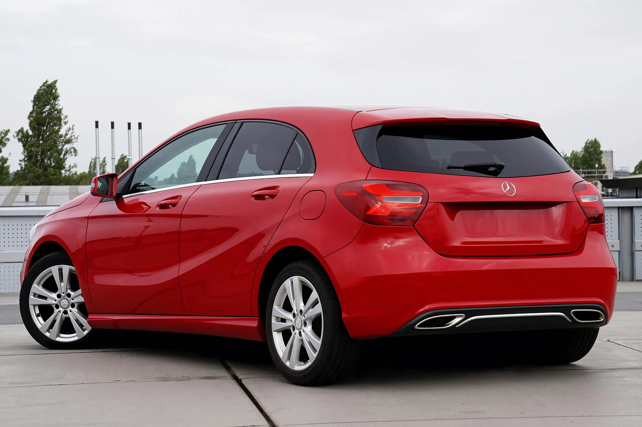 Compact Red Mercedes Benz Hatchback in Open Area Wallpaper