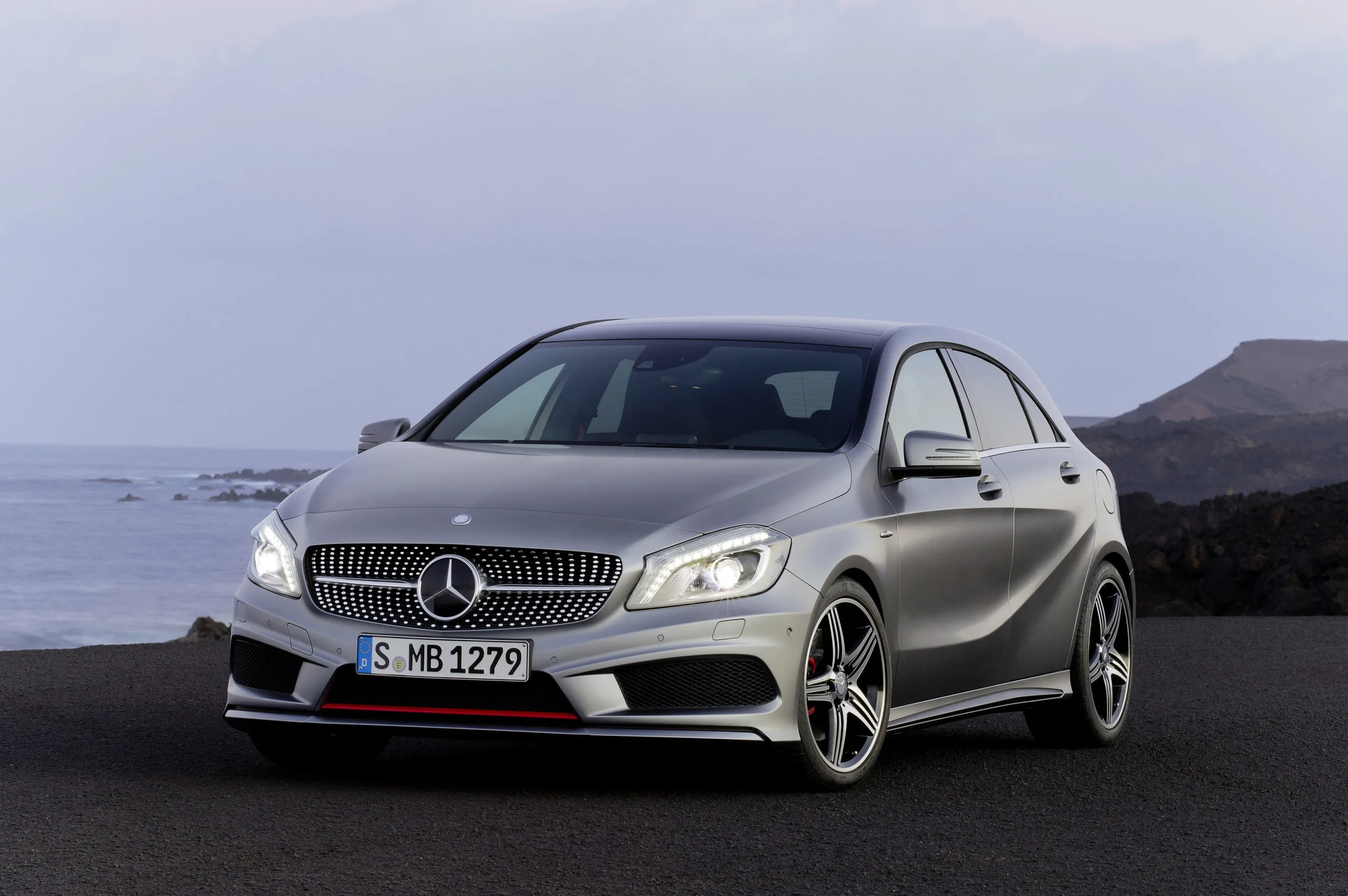 Compact Silver Mercedes Posed on Ocean Highway Wallpaper