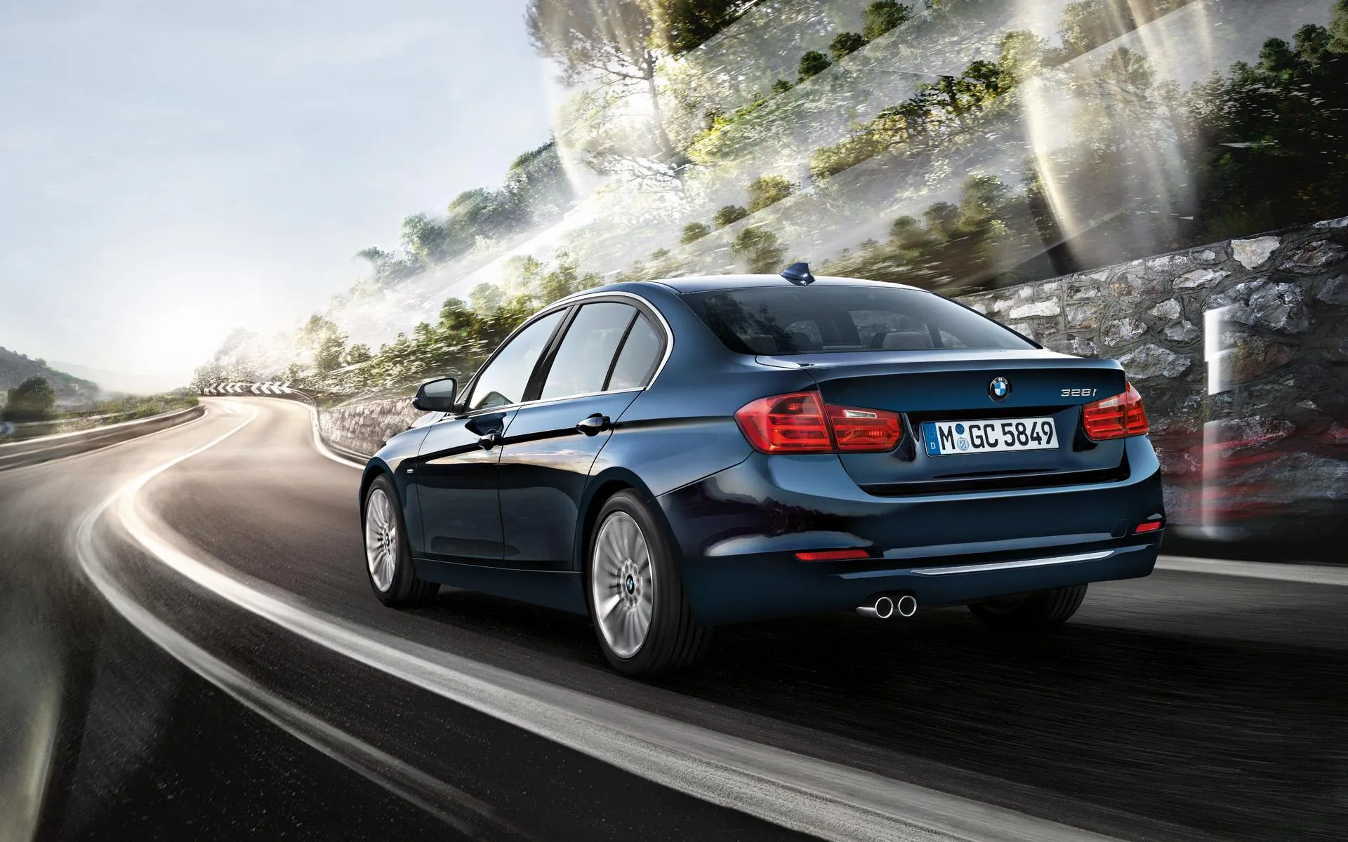 Dark Blue Bmw Sedan Driving on a Sunny Tree Lined Road