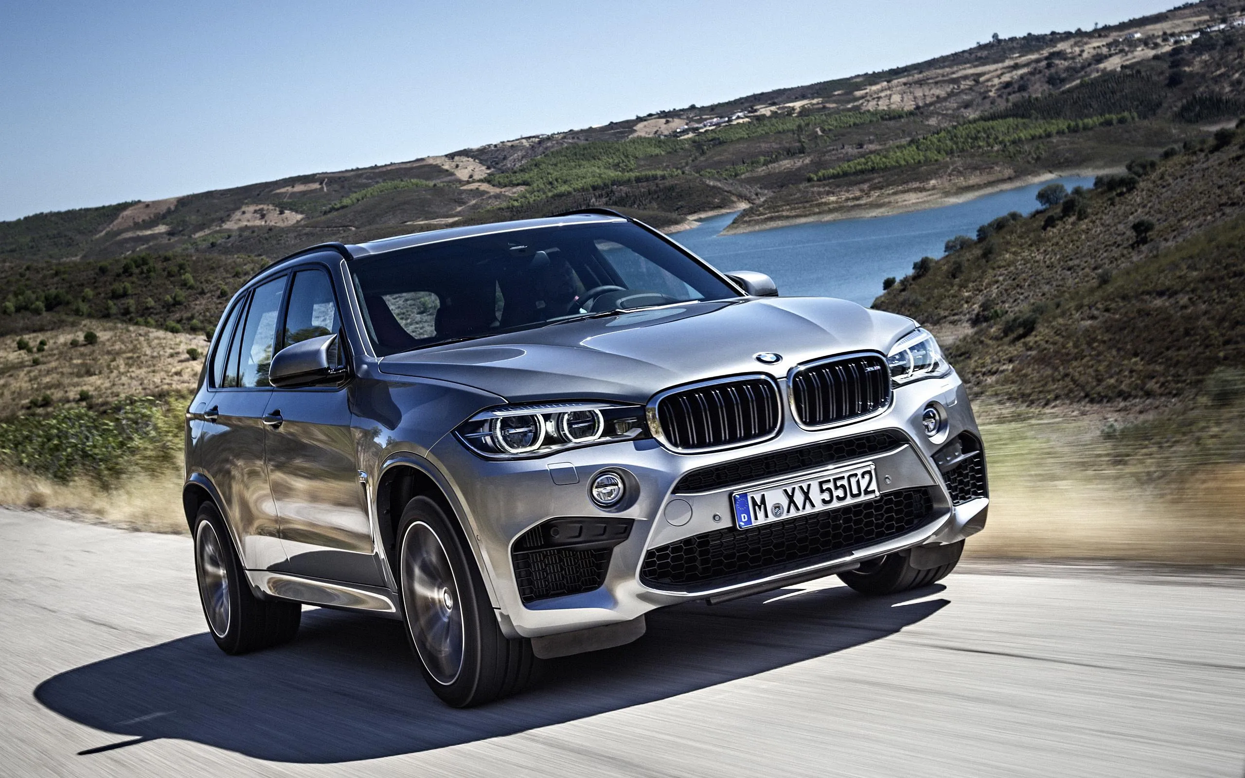 Dark Bmw Suv Driving Through Winding Mountain Highway