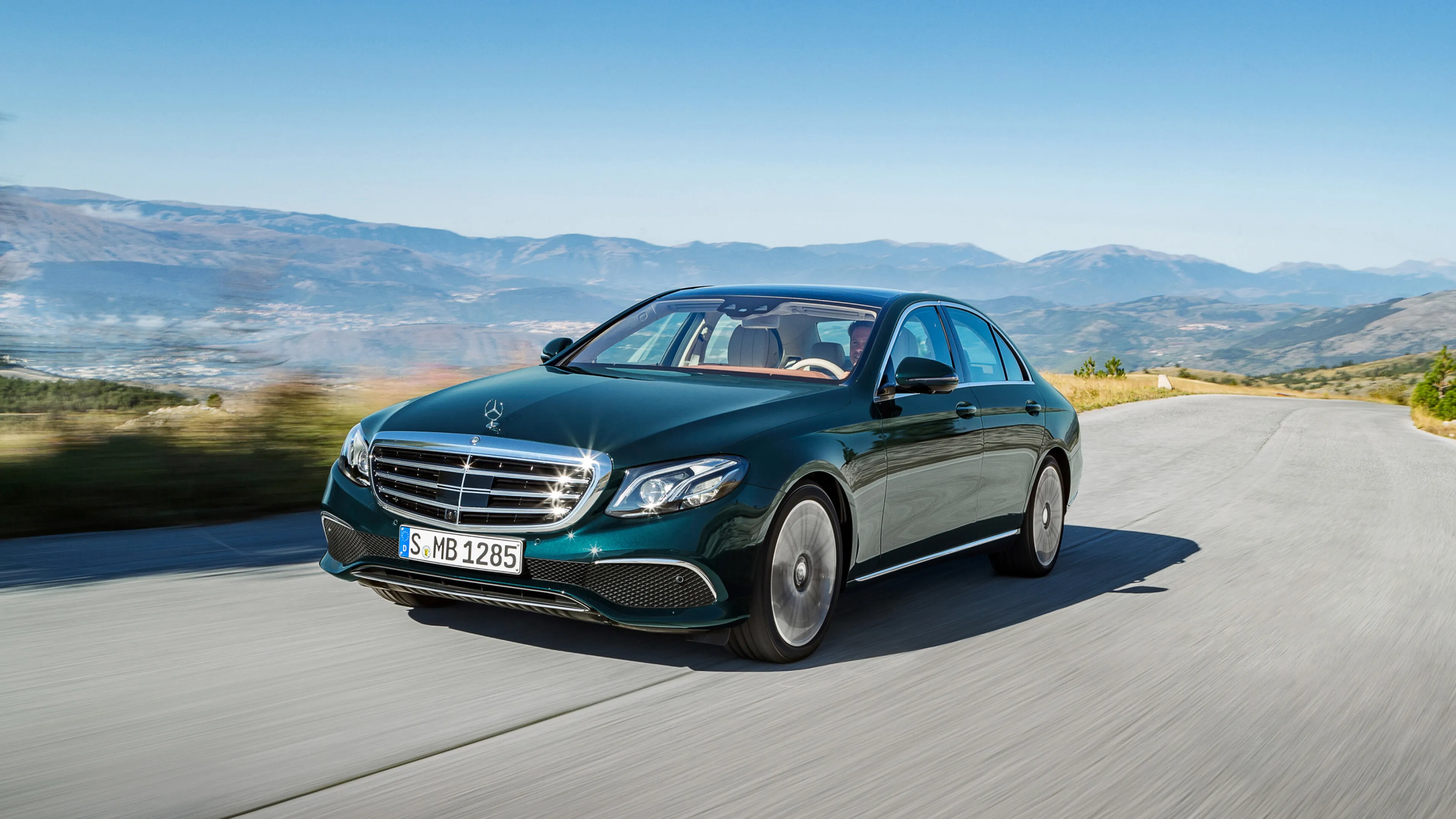 Dark Green Mercedes Benz Luxury Sedan Driving in Countryside
