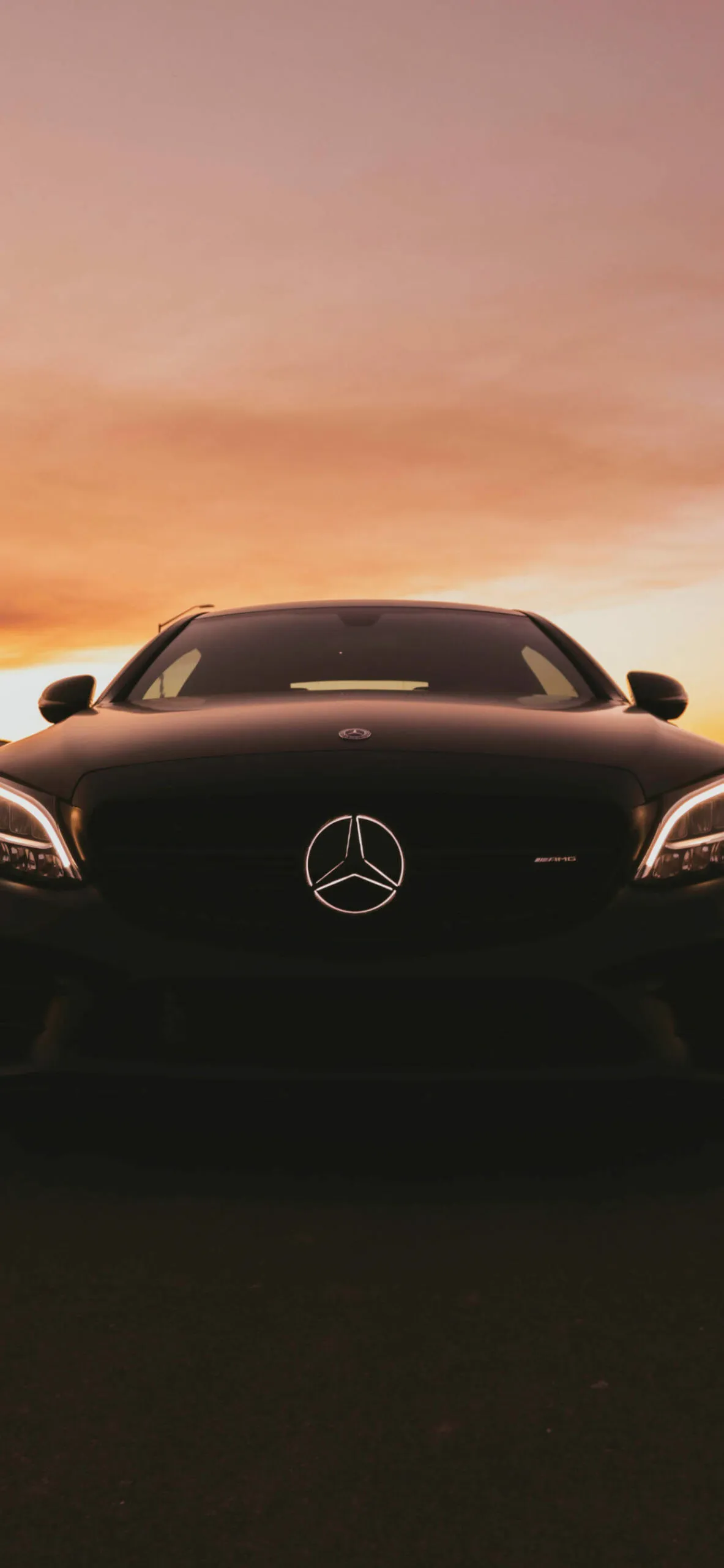 Dark Mercedes Coupe Against Sunset Backdrop Wallpaper