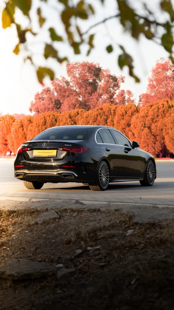 Dark Mercedes Driving Past Autumn Trees Roadside Wallpaper