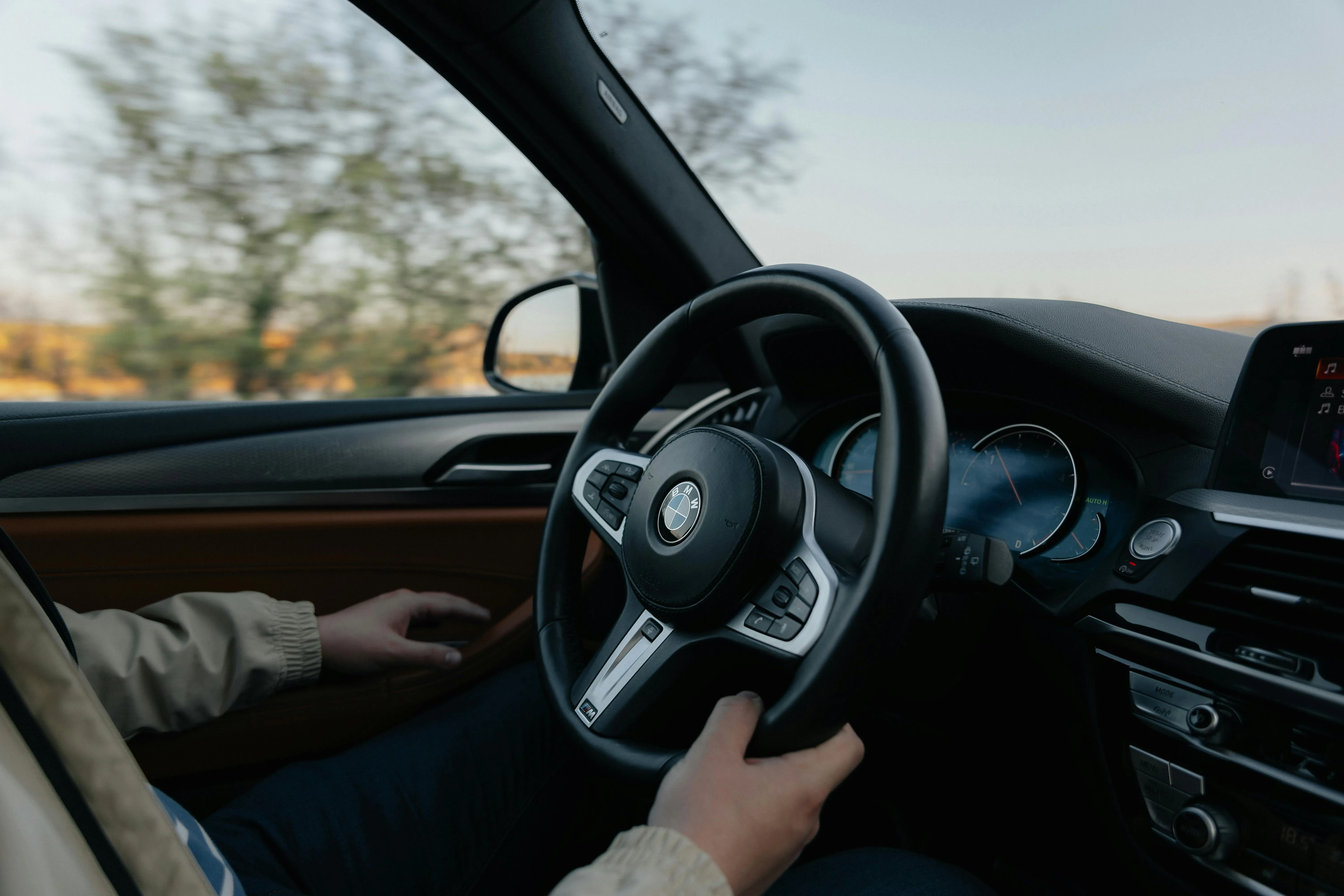 Driver Holding Steering Wheel Inside Bmw During Sunrise