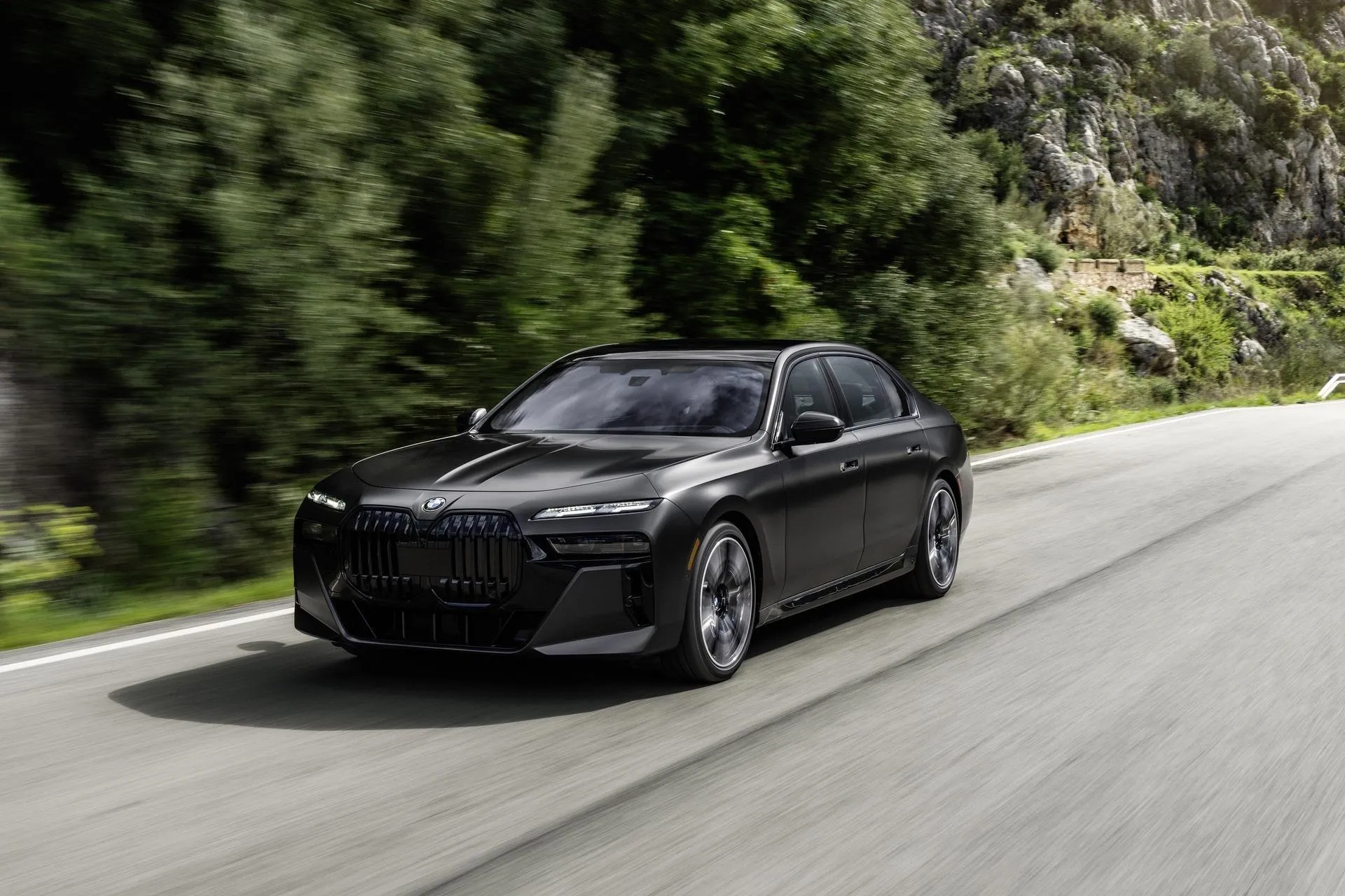 Elegant Black Bmw Sedan Driving on Mountain Road Wallpaper