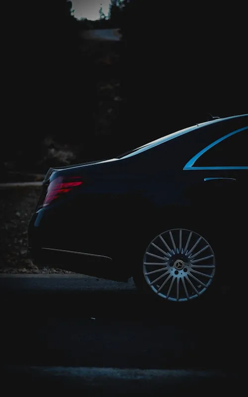 Elegant black Mercedes luxury sedan parked in low light