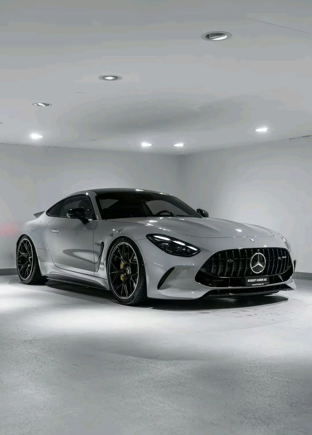 Elegant White Mercedes Benz in Modern Showroom Wallpaper