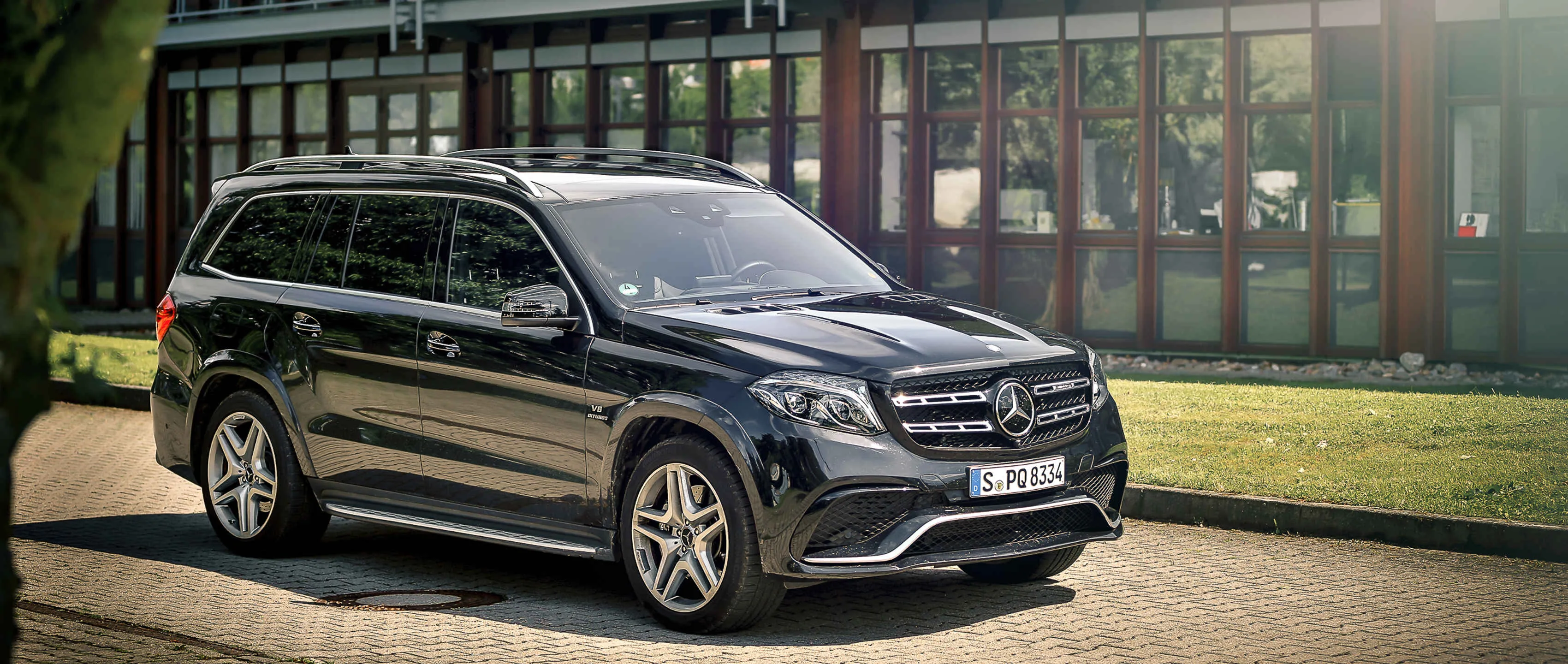 Family Mercedes SUV Parked Near Modern Building Wallpaper