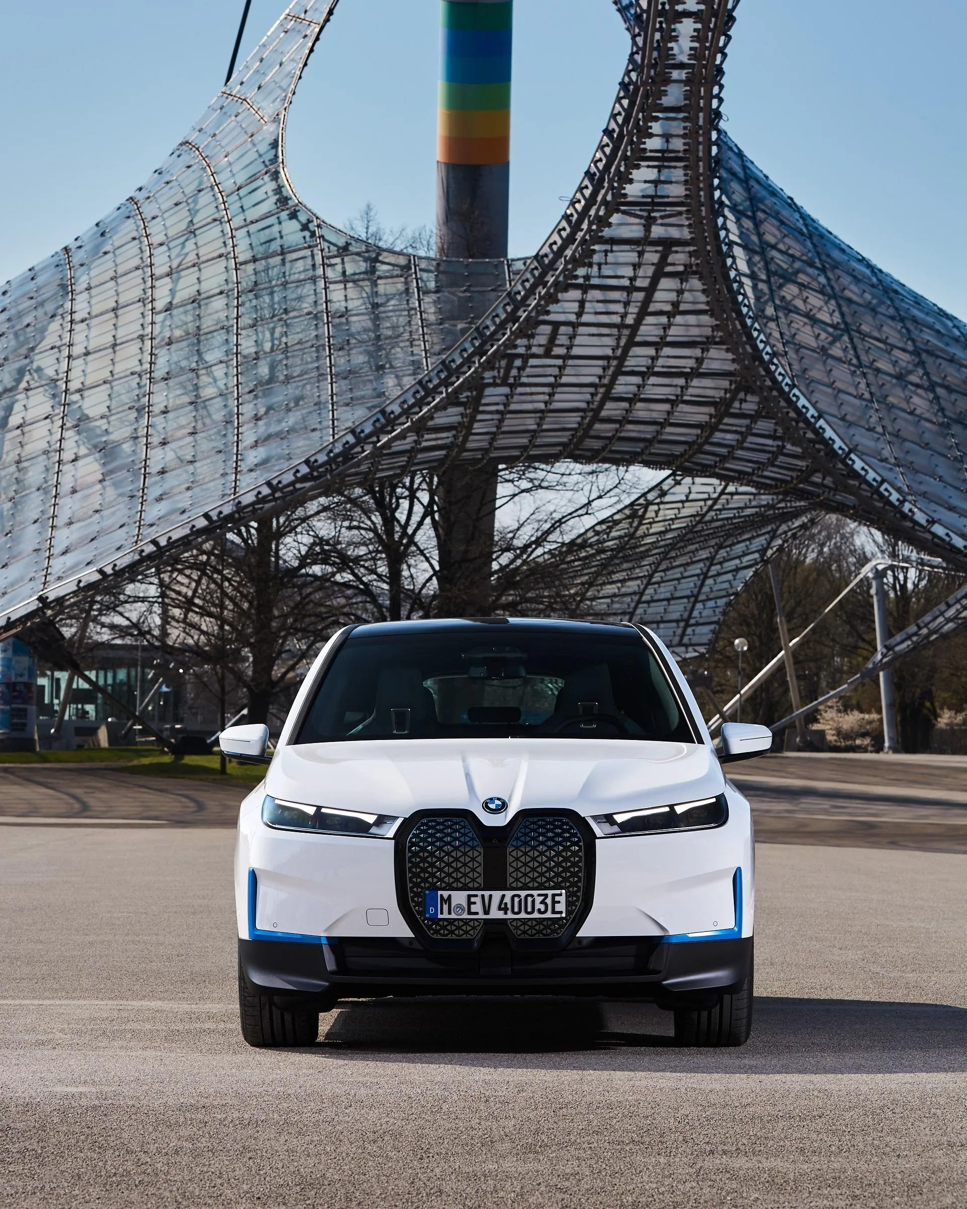 Front View of a White Bmw Suv in Front of a Tower Wallpaper
