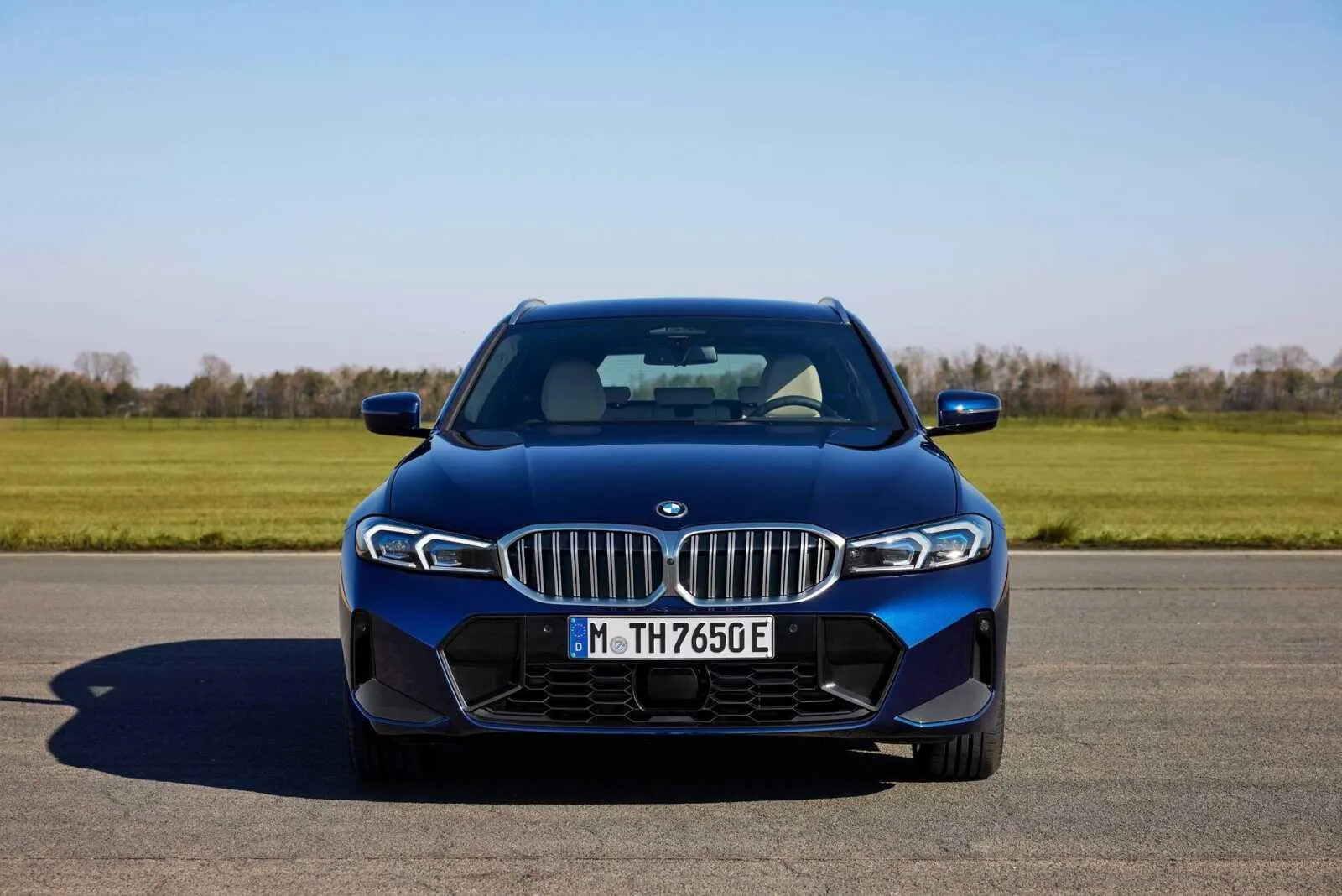 Front View of Blue Bmw Sedan Parked on Open Field Road