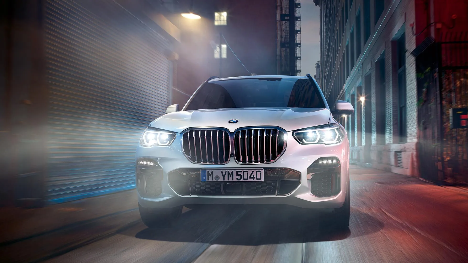 Front View of Bmw in Motion on a Street at Night Wallpaper