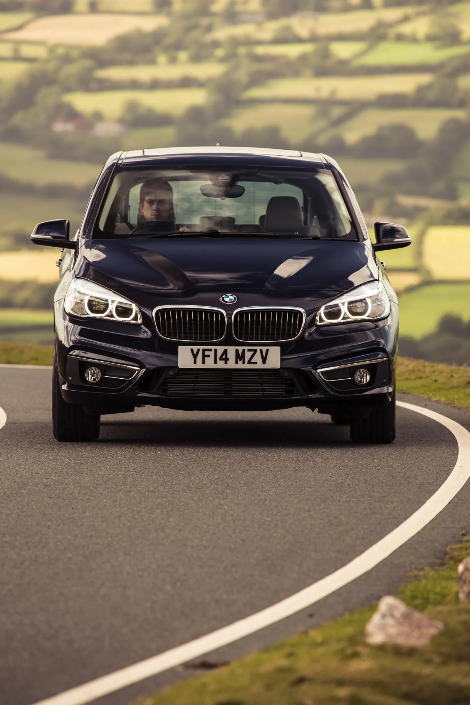 Front View of Bmw Suv Driving on Curved Country Road