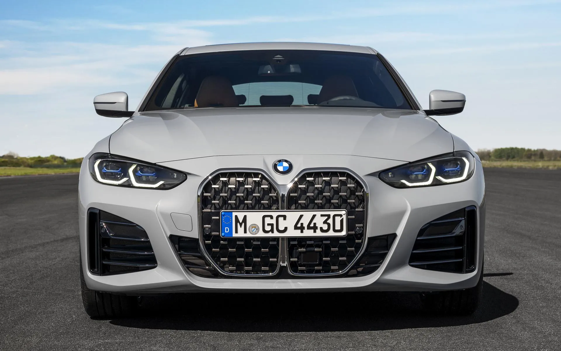 Front View of White Bmw Parked on Empty Roadside Image