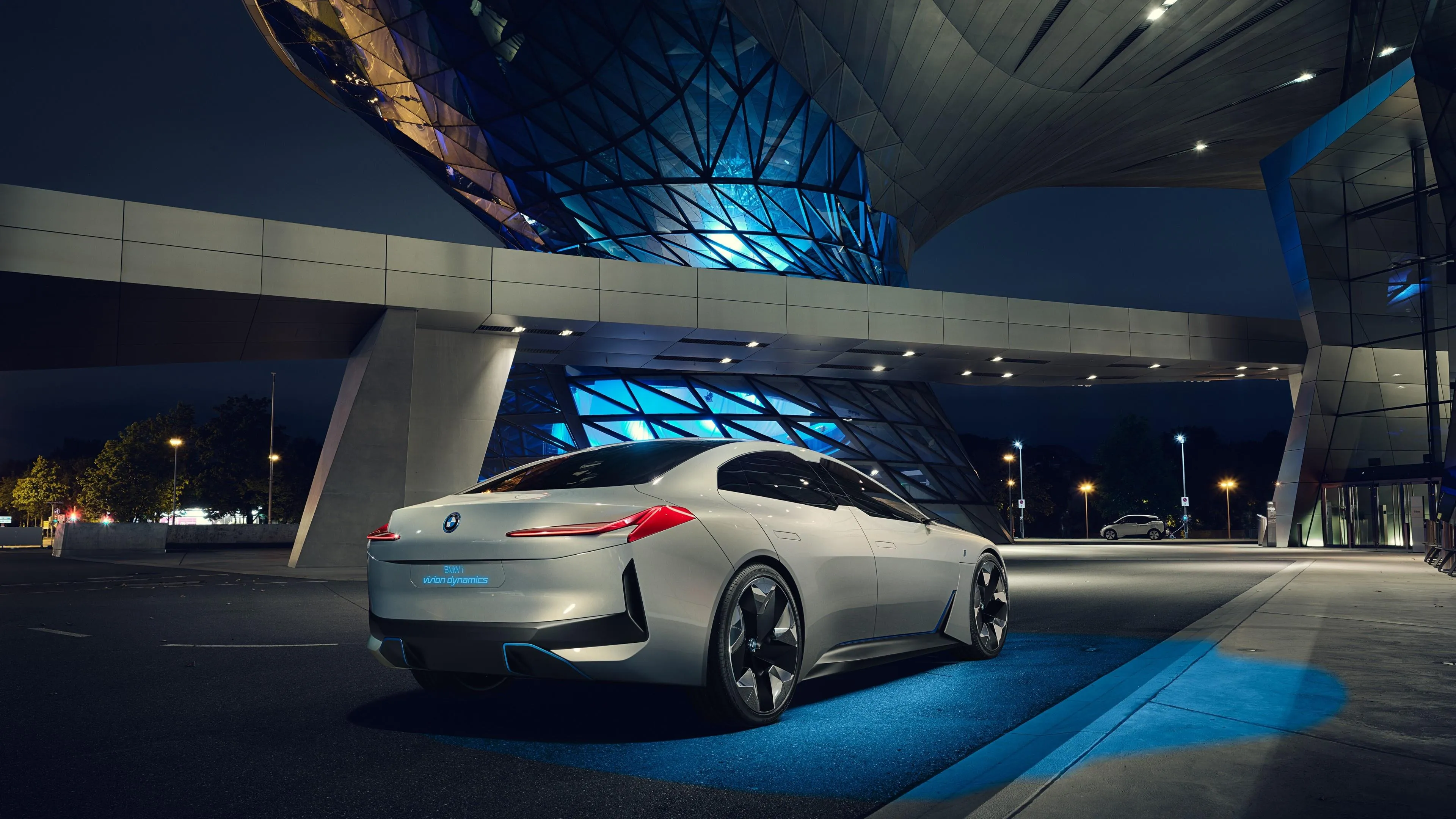 Futuristic Bmw Parked Under Modern Urban Lights Wallpaper
