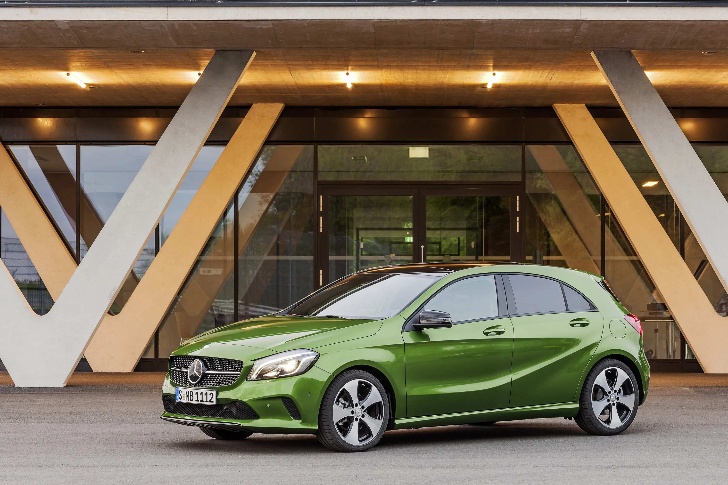 Green Mercedes Benz Compact Car Parked near Building image