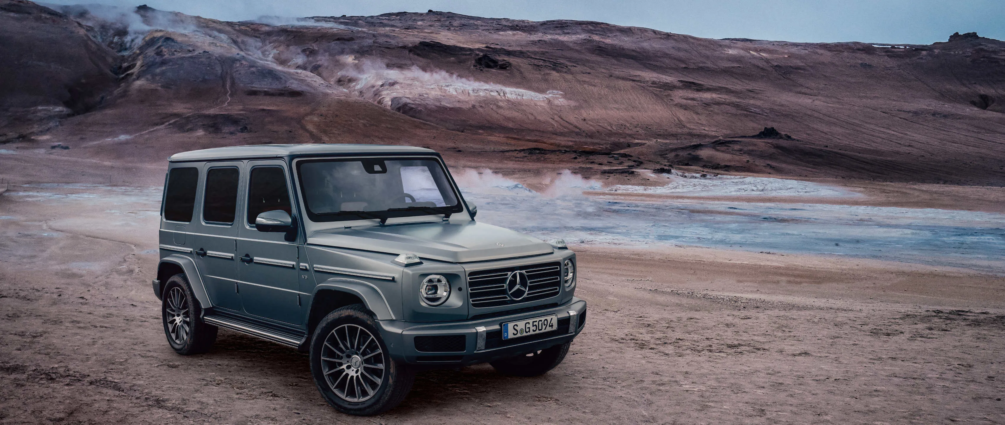 Green Mercedes G Wagon Parked in Rocky Desert Wallpaper