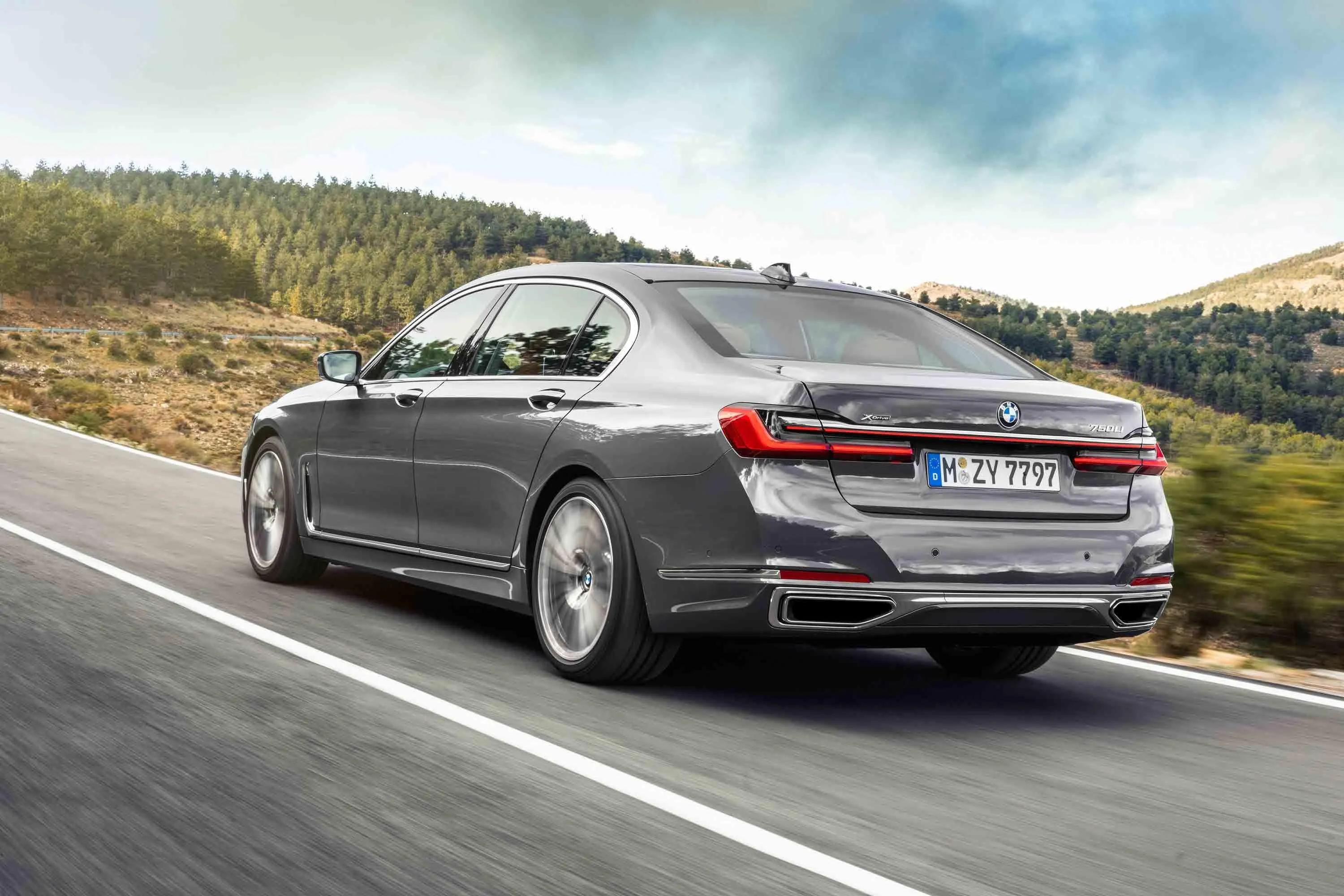 Grey Bmw Sedan Driving on Open Road Near Green Hillside