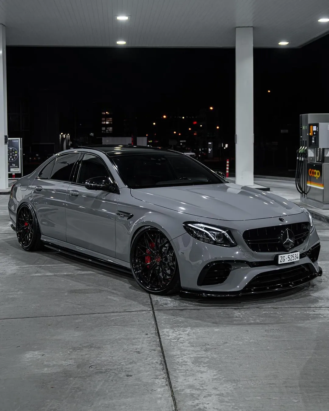 Grey Mercedes AMG Fueling at Nighttime Gas Station