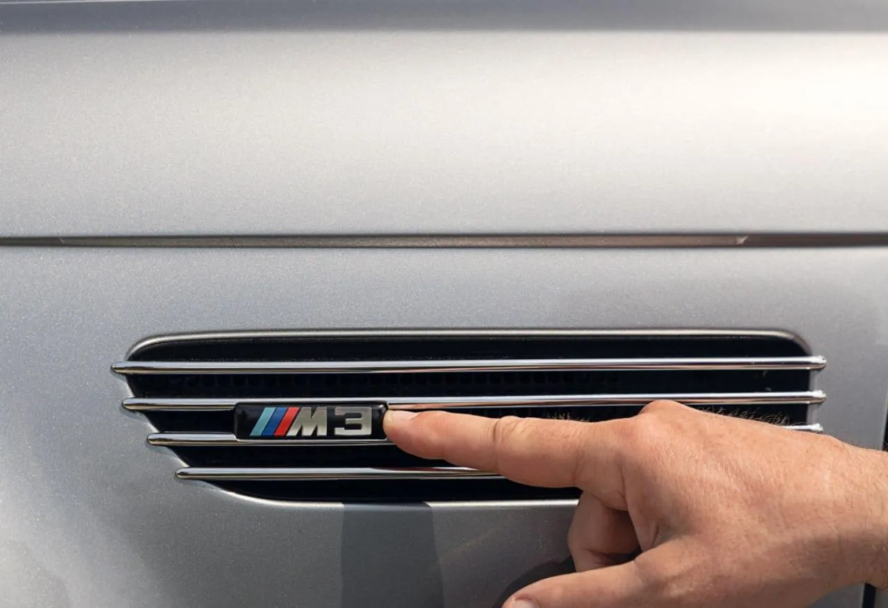 Hand Pointing To Bmw M Badge on Air Conditioning Vent