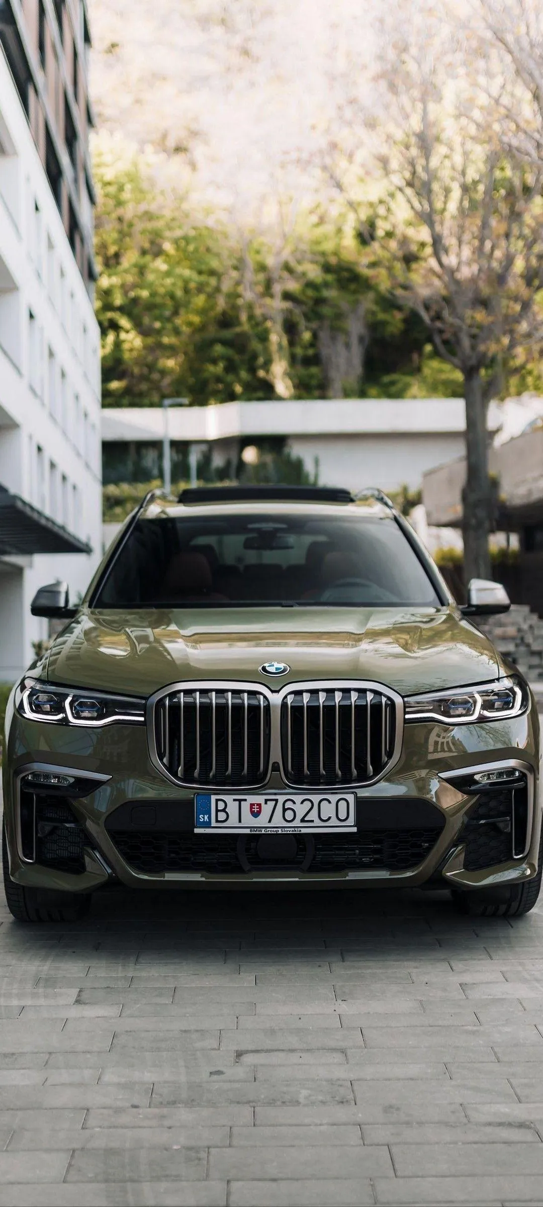 Luxury Black Bmw Suv Parked Between Urban High Rise Buildings