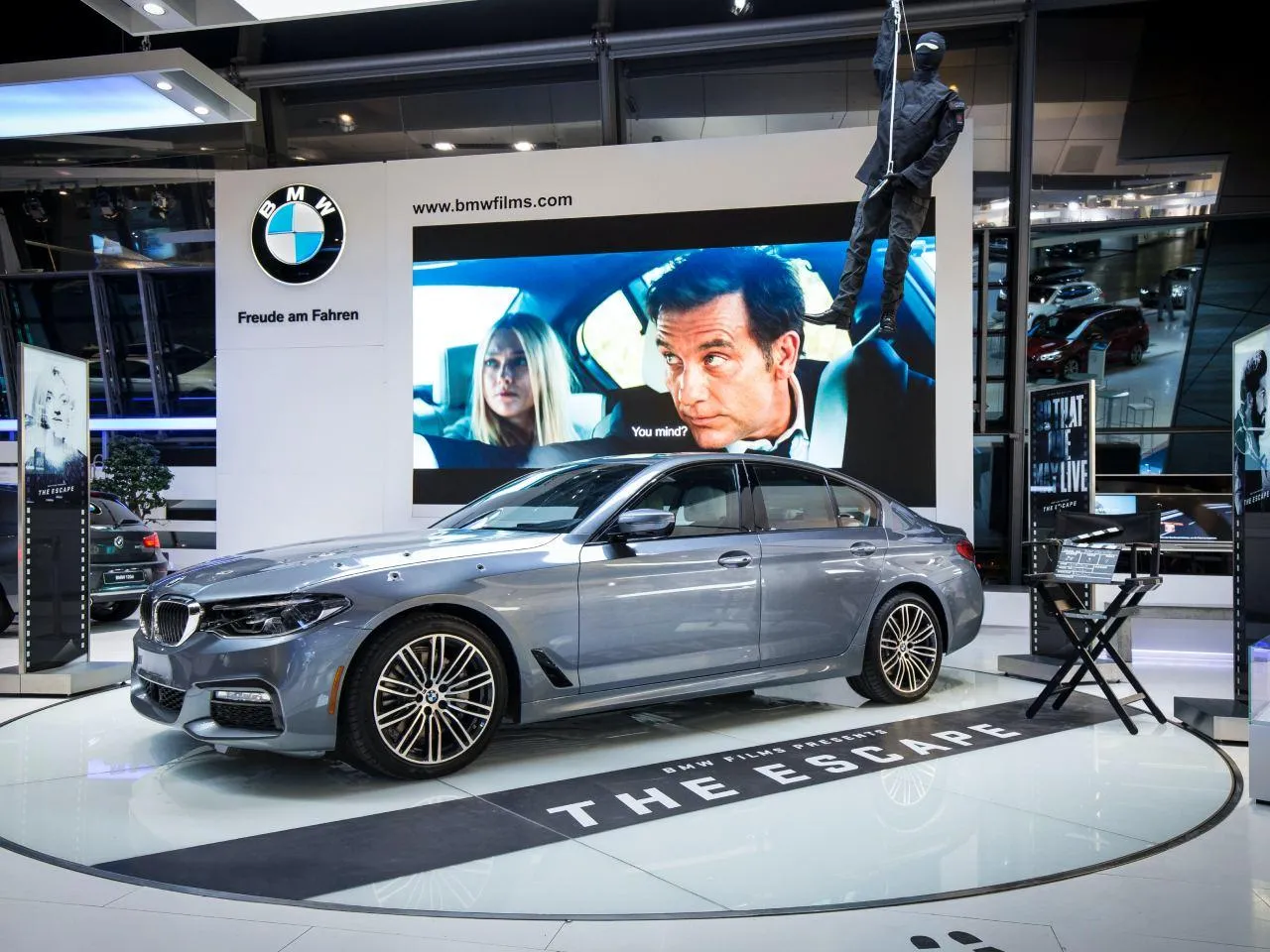 Luxury Bmw on Display at an Auto Show with Poster Backdrop