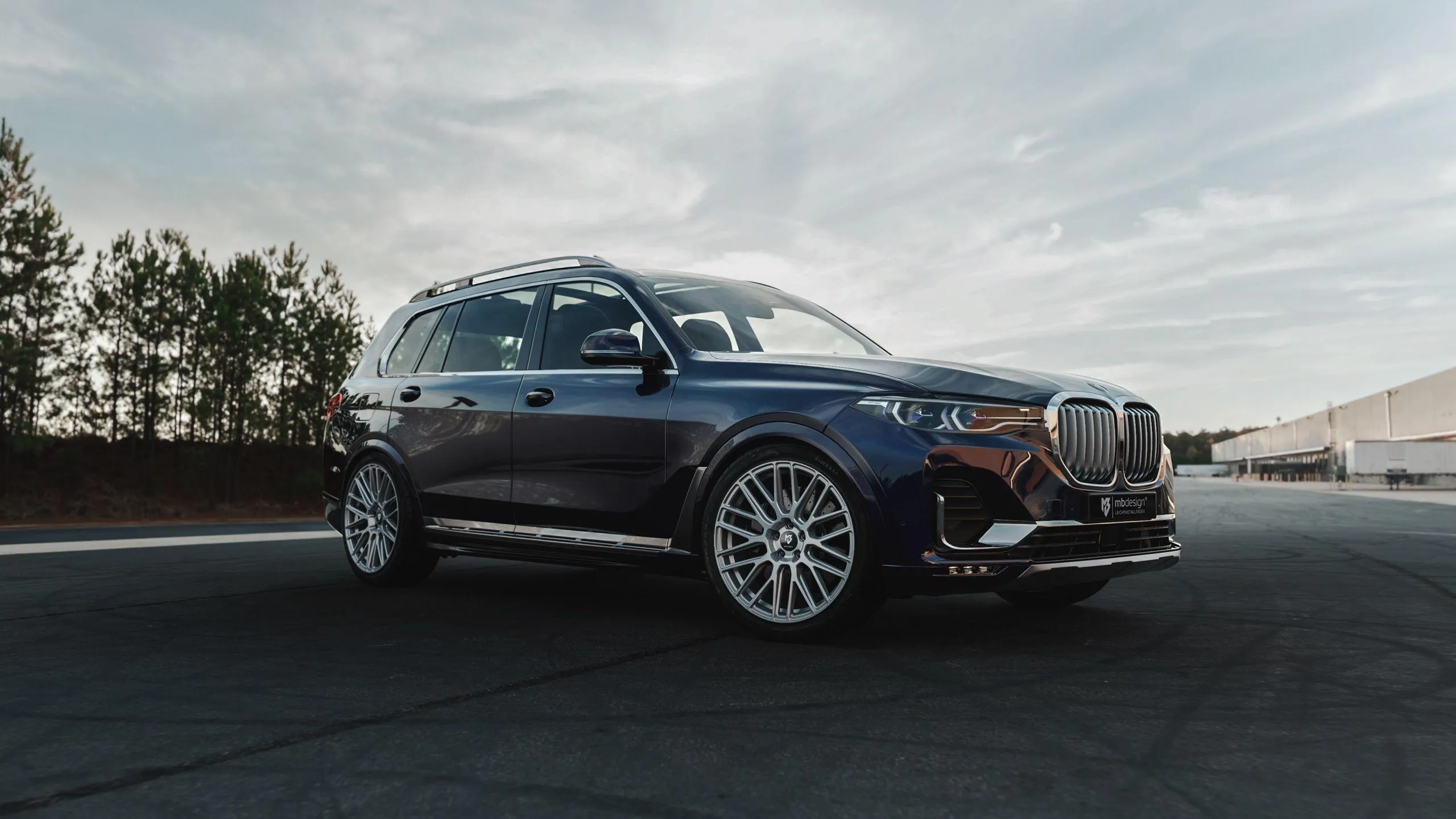 Luxury Bmw Suv Driving Along a Scenic Urban Road Wallpaper