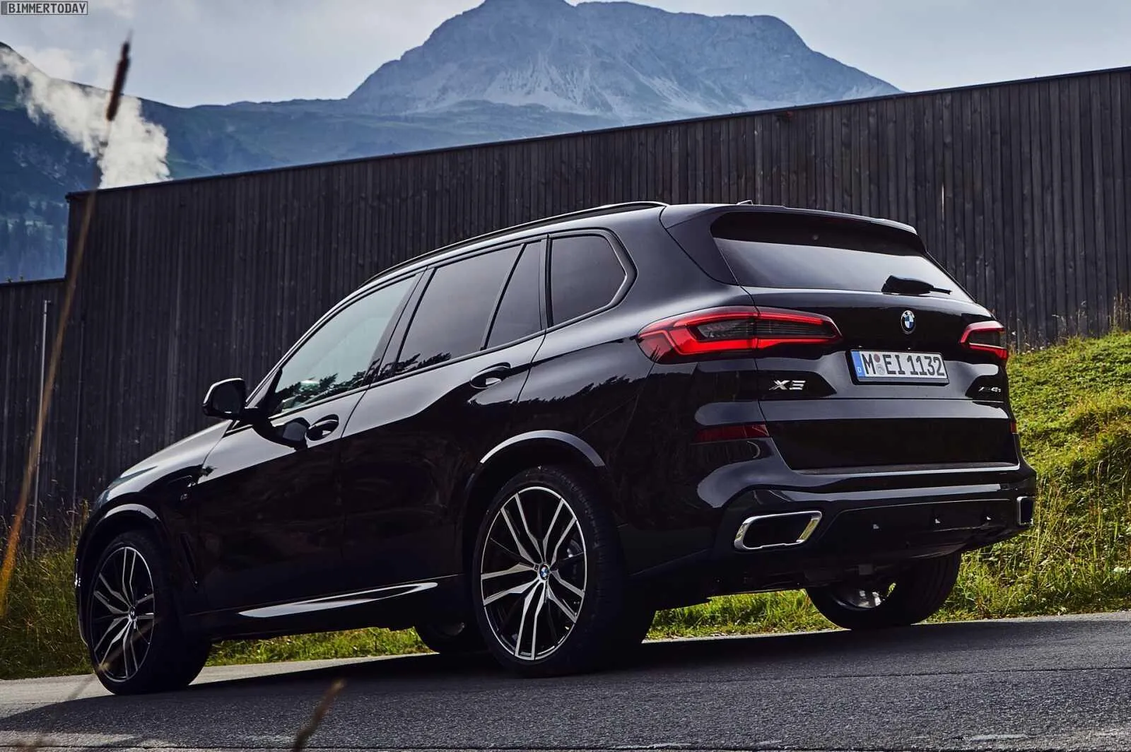 Luxury Bmw Suv Parked Beside Modern Wooden Building