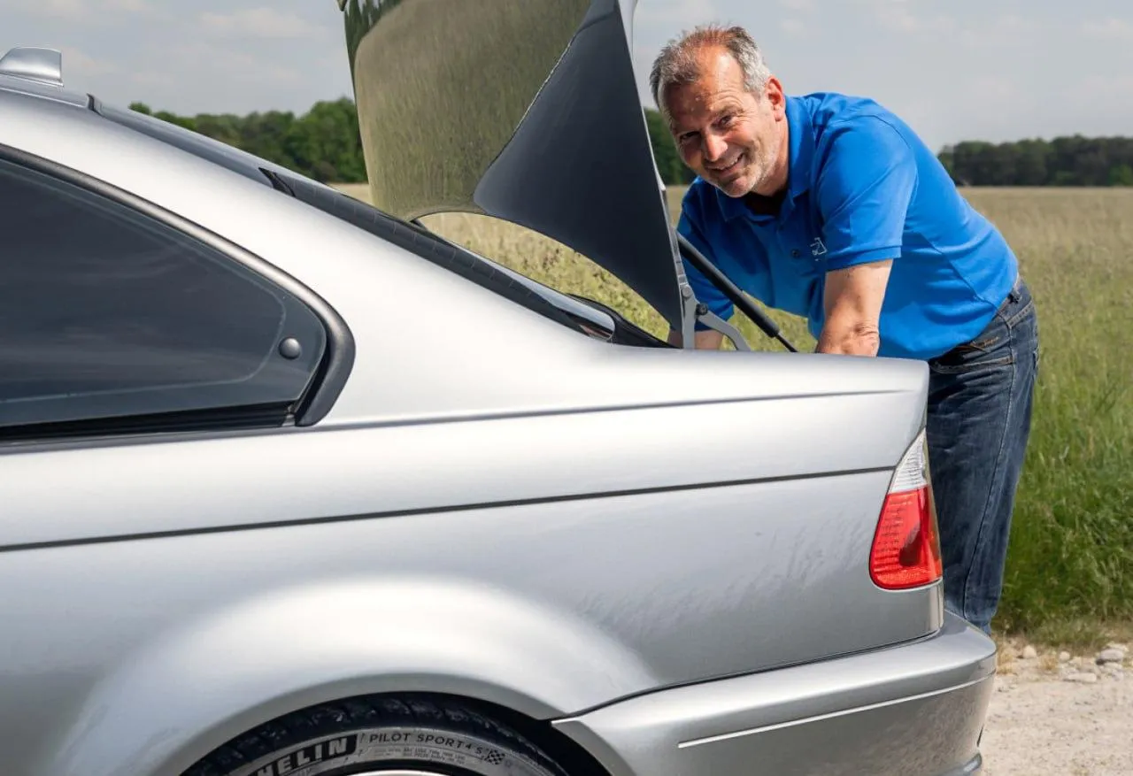 Man Polishing Silver Bmw Coupe in Outdoor Setting Image