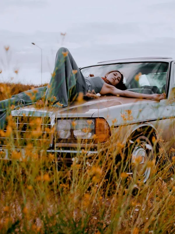 Man Relaxing in Vintage Benz in a Field of Weeds Wallpaper