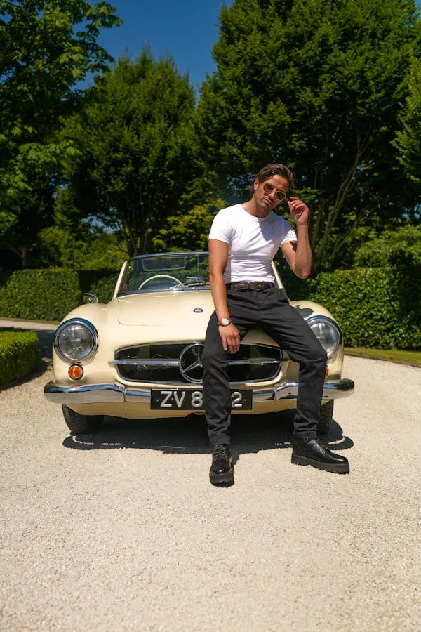 Man Sitting on Classic Mercedes Benz in Outdoor Setting