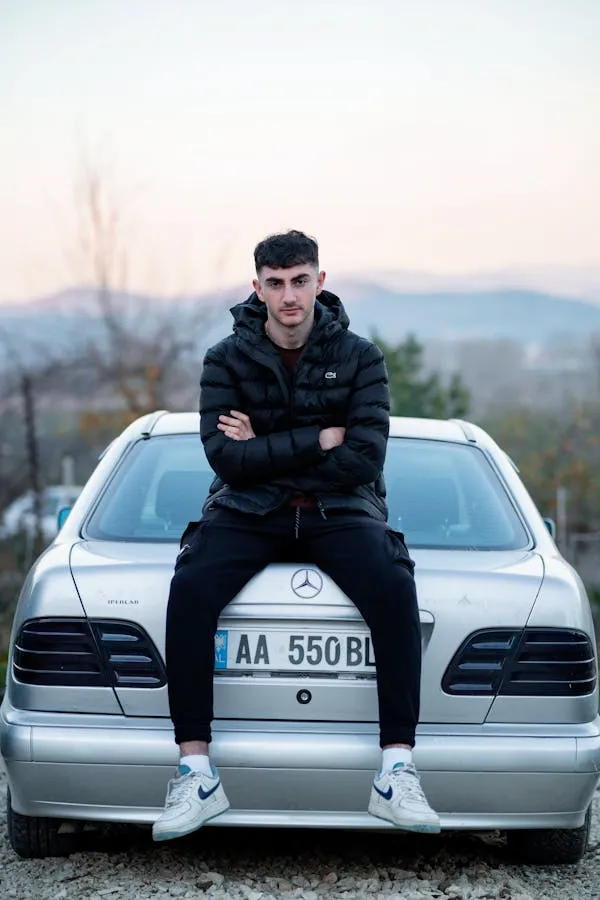 Man Sitting on Mercedes Benz with Scenic Mountain View