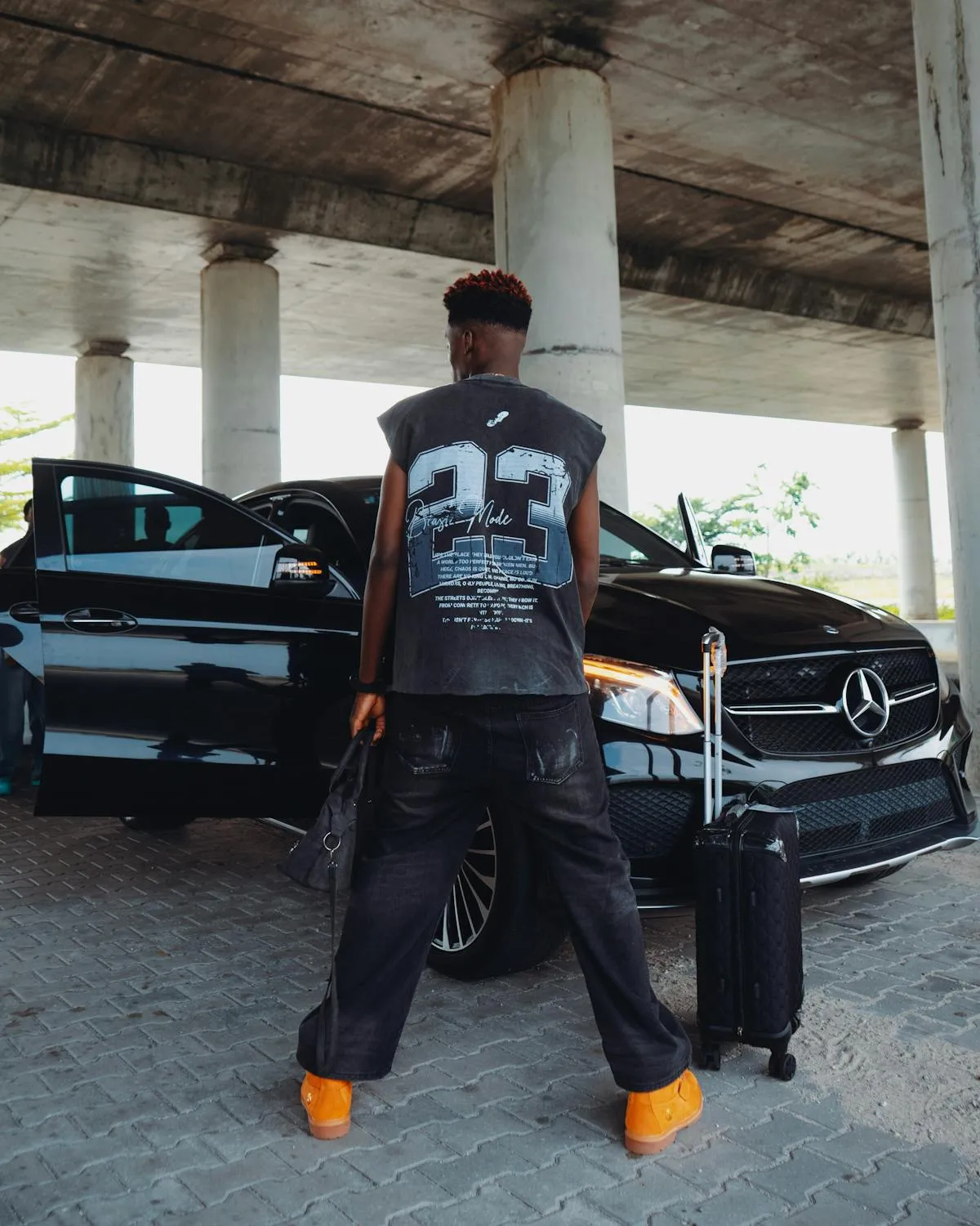 Man Standing Near Mercedes Sedan Under Urban Bridge