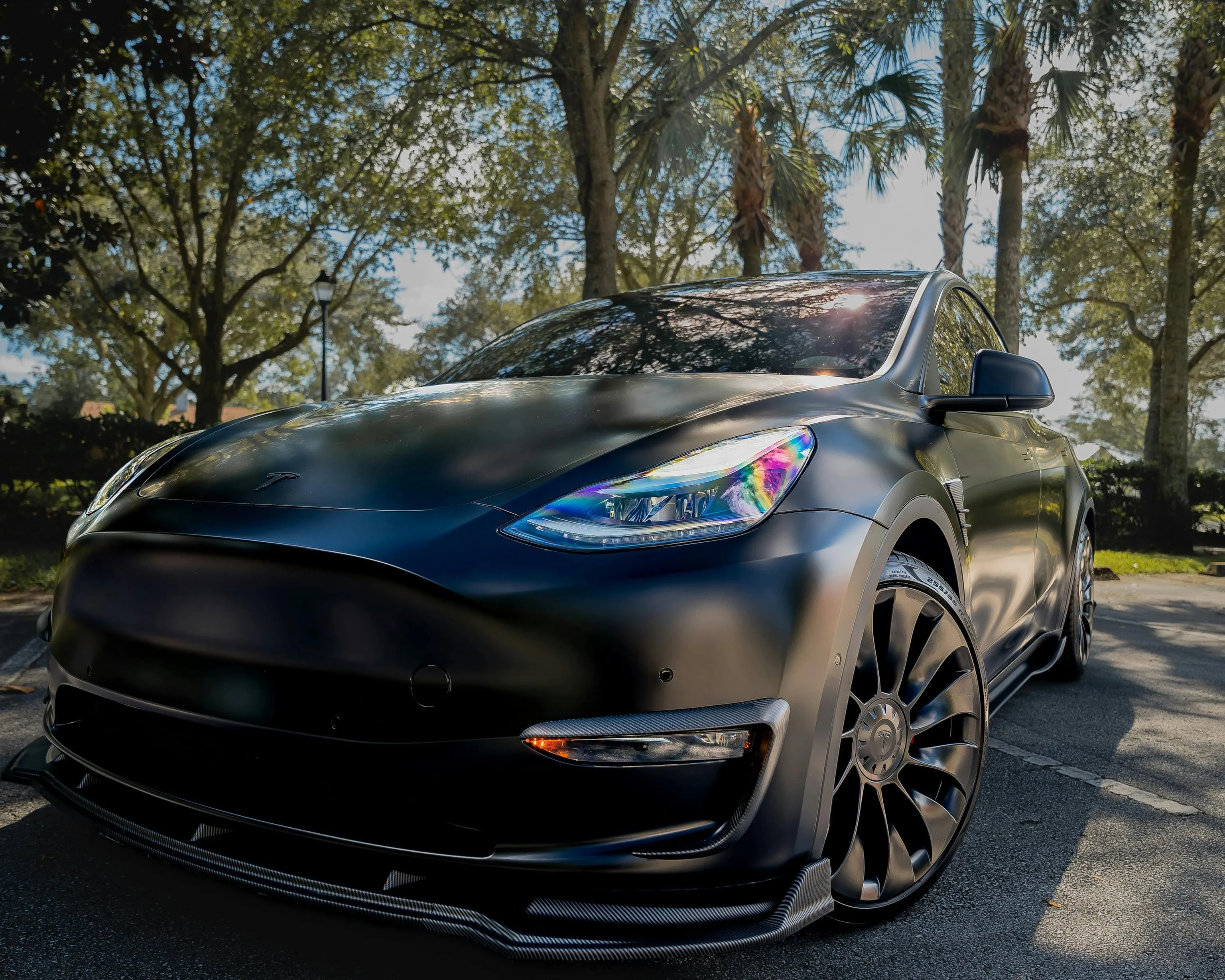 Matte Black Tesla Model Y with colourful headlight 4k image