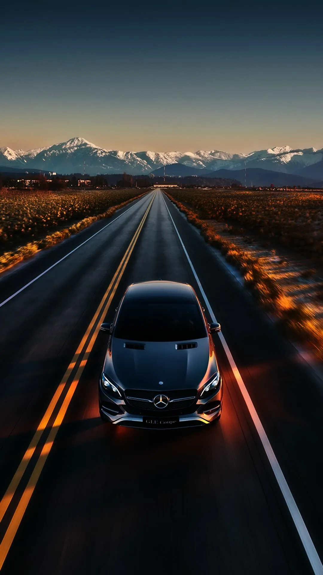 Mercedes Benz Driving Down Road with Mountain Background