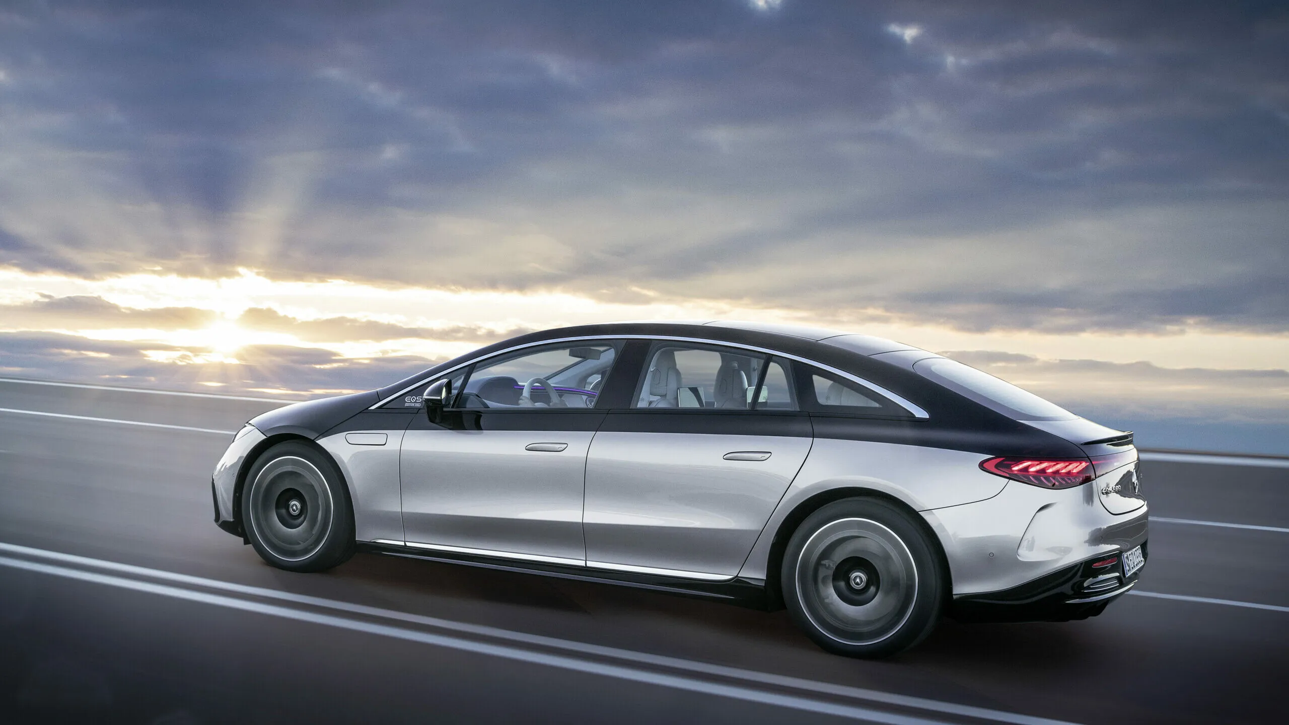 Mercedes Benz luxury sedan driving on a scenic road Wallpaper