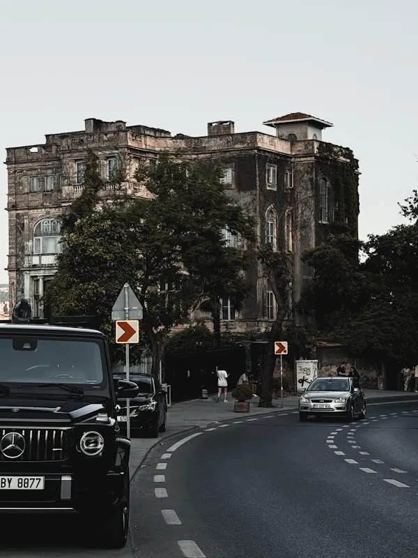 Mercedes Benz SUV Driving on Urban Road with Old Building