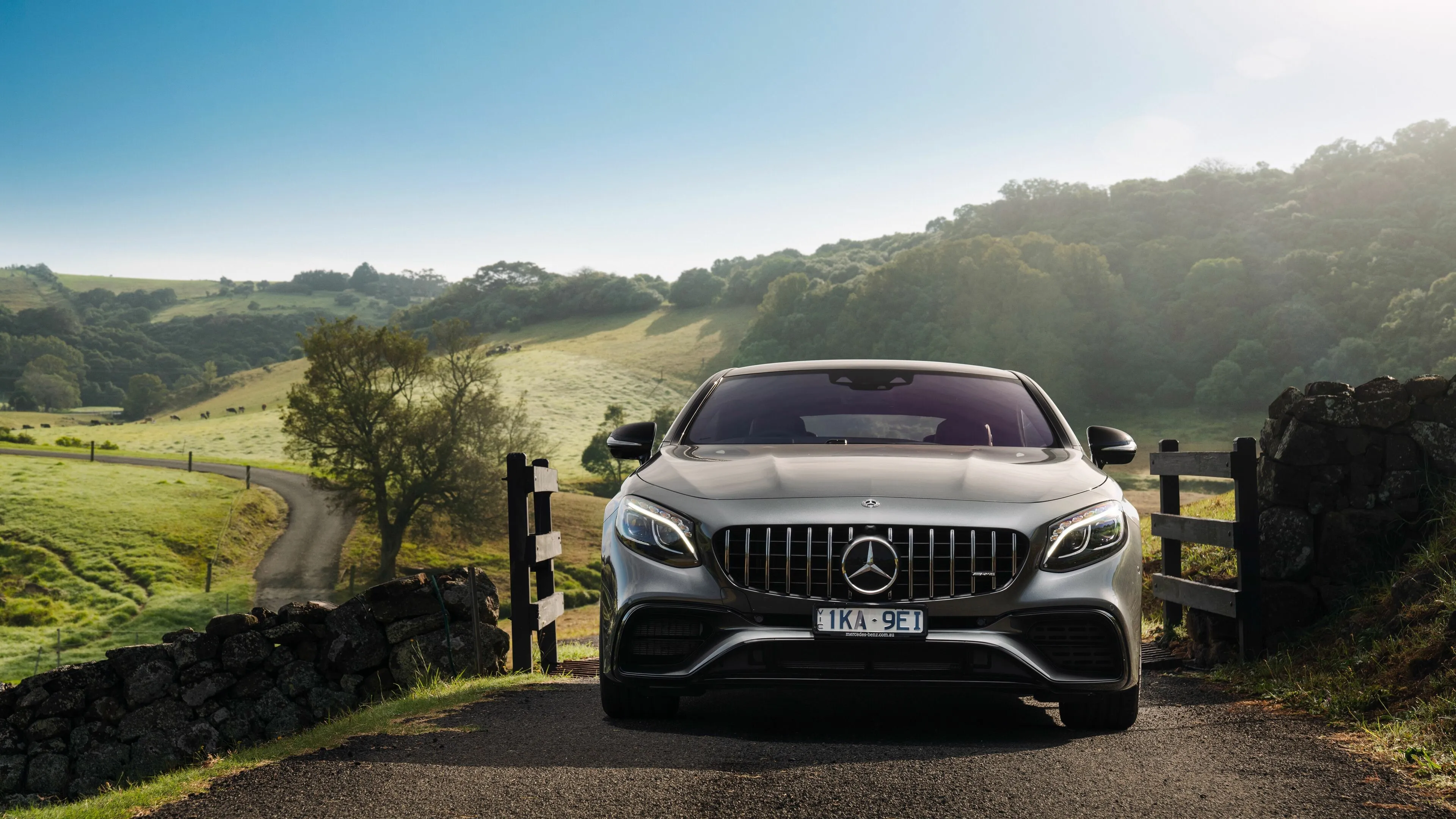 Mercedes Benz SUV on Rural Road with Scenic Hills Behind