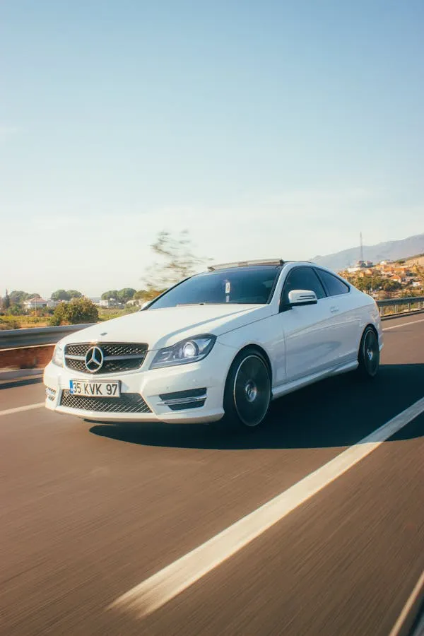 Mercedes Benz White Car Driving on Open Highway Wallpaper