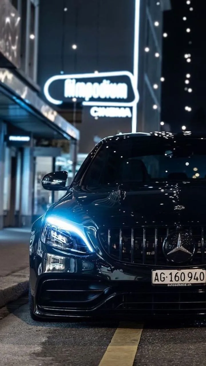 Mercedes Benz with Headlights On at Night in Urban Scene