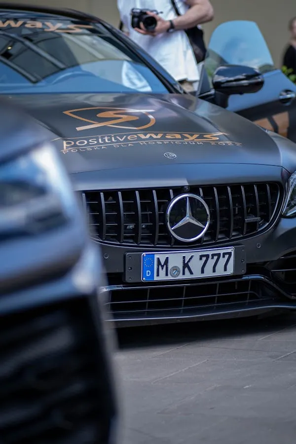 Mercedes car with emblem and logo on front grille Wallpaper