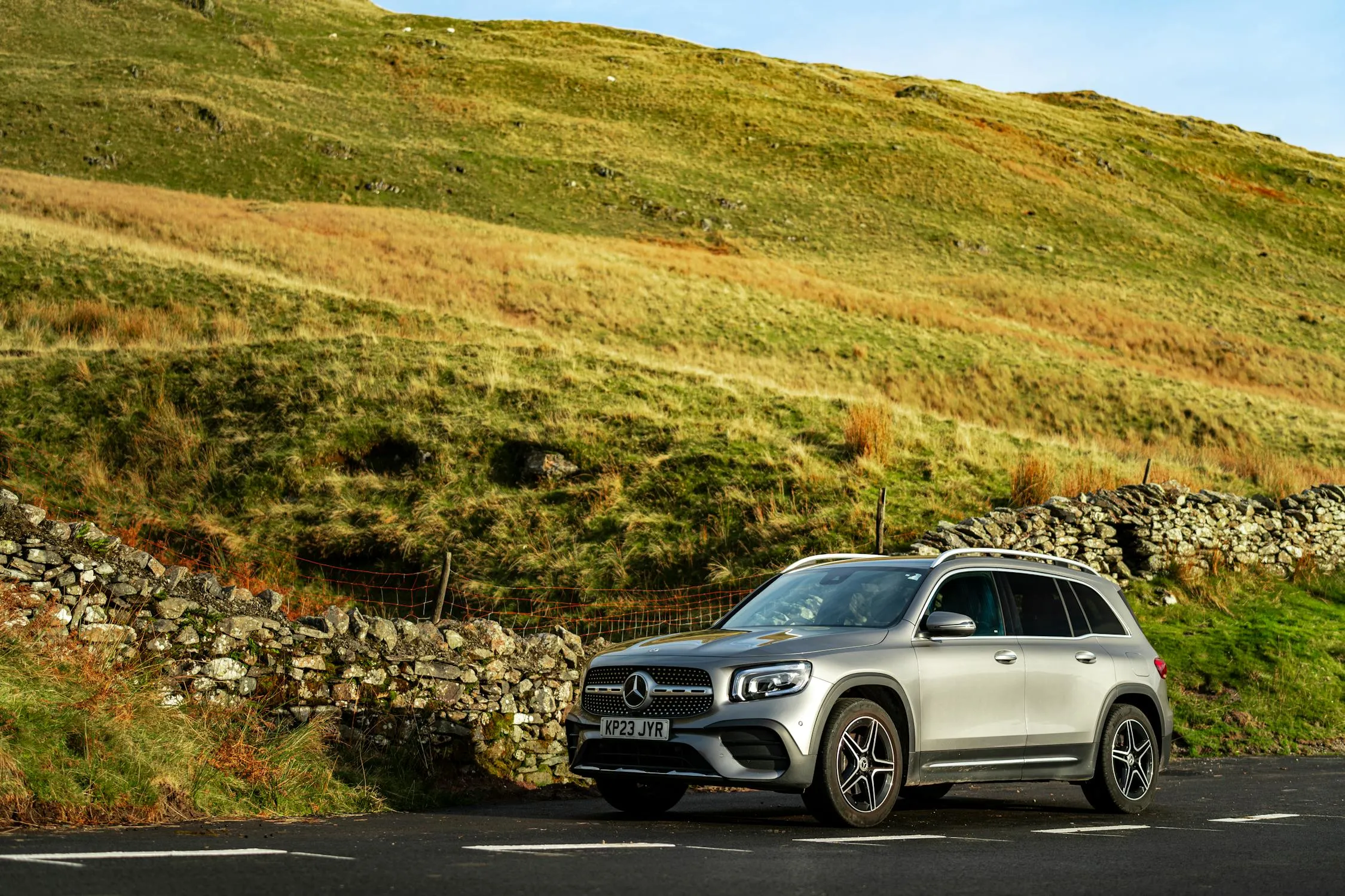 Mercedes Estate Vehicle Parked in Lush Green Hills Wallpaper