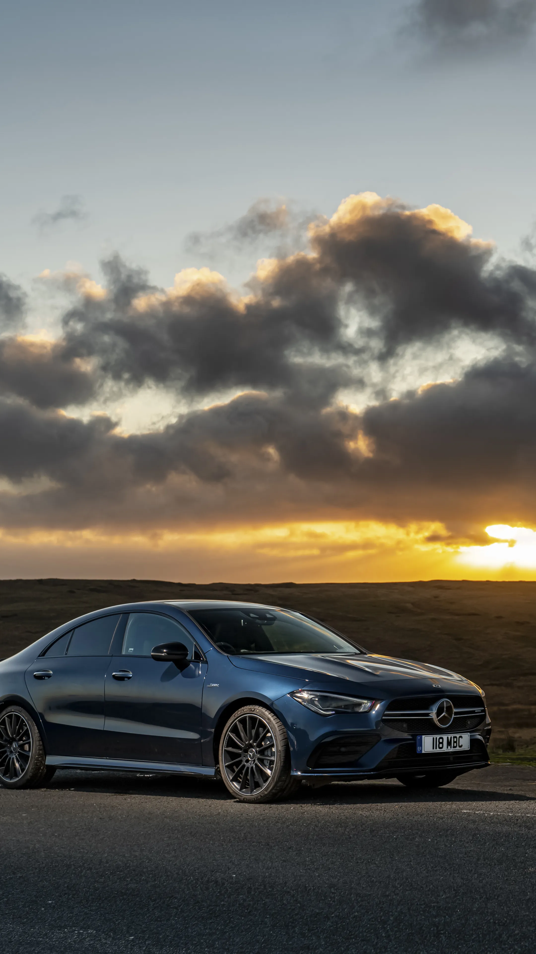 Mercedes Sedan at Sunset with Dramatic Cloudy Sky Wallpaper